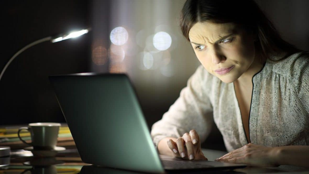 Suspicious woman checking laptop content in the night